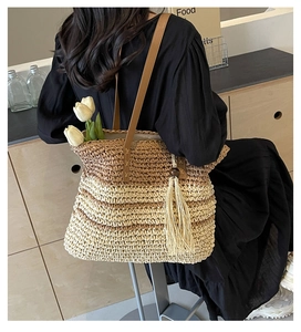 Detail of bohemian woven tote bag with side fringe tassel and leather shoulder strap