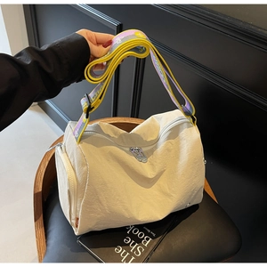 Detail of cream casual crossbody bag featuring colorful wide strap and zipper pocket