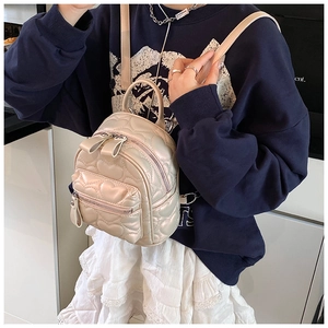 Detail of heart quilted mini backpack with pearlescent finish and front zipper pocket