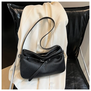 Detailed close-up of a black pleated leather bucket bag with silver metal ring hardware