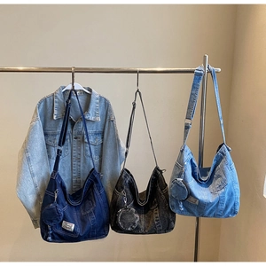 Dettaglio di grandi borse tote in denim nei colori blu scuro, grigio nero e azzurro
