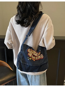Large denim shoulder bag with embroidered 'Lookin Good' text and adjustable strap