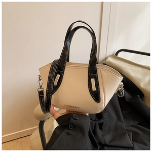 Detail of a chic cream and black bucket bag with Fashion & Bags text and top handle