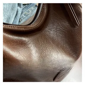 Détail macro de la texture simili-cuir vintage marron foncé et de l'étiquette embossée