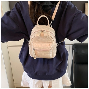 Detailed back view of beige quilted heart mini backpack with adjustable pink straps