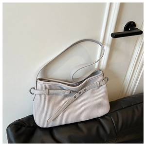 Detail of light gray bucket bag showing vertical pleated leather texture and metal buckle