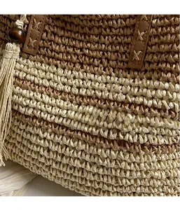 Detail of two-tone woven tote featuring scales pattern, wood beads, and tassel accents