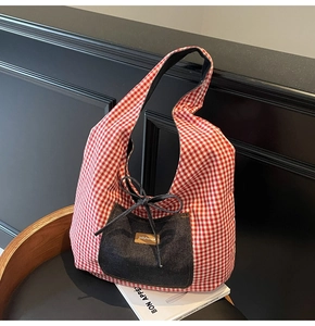 Close-up of red and white checkered tote bag featuring a blue denim pocket detail