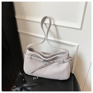 Close-up of vertical pleated texture and silver eyelet belt on a grey-purple tote bag