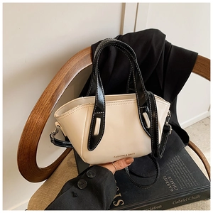 Detail of cream white tote bag with black straps on a wooden chair in office setting