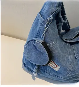 Dettaglio della borsa in denim con portamonete rotondo staccabile e moschettone in metallo