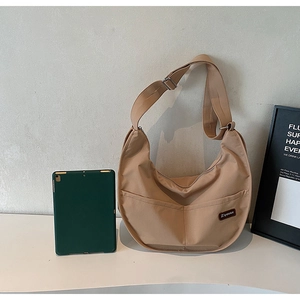 Large khaki nylon tote bag showing interior space with a tablet for size reference