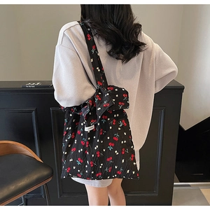 Detailed back view of pleated cherry print tote bag with branding and shoulder strap