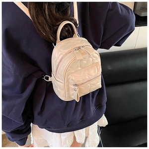 Detail of heart quilted cream PU leather mini backpack showing the fine stitching and texture