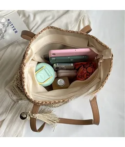 Detail view of large straw tote interior with leather handles and spacious storage