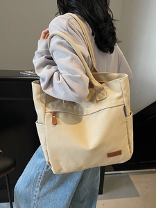 Large beige canvas tote bag with shoulder strap and side pocket for daily commute