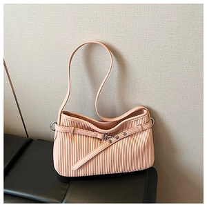 Detailed view of peach pleated shoulder bag with decorative strap and silver eyelets