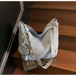 Dettaglio della borsa tote in denim azzurro con ampie tasche e mini portamonete rotondo