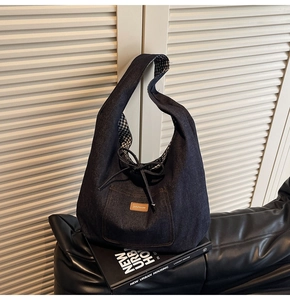 Detail of denim tote bag showing brown leather label and black and white checkered lining