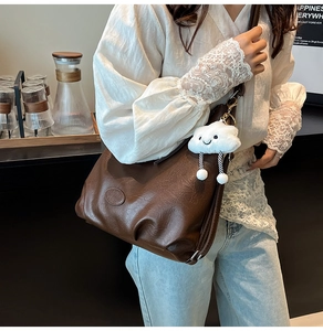 Détail du sac marron foncé plissé vintage avec breloque nuage en intérieur moderne