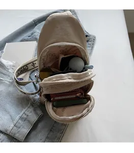 Interior view of khaki nylon crossbody bag showing storage space for phone and wallet