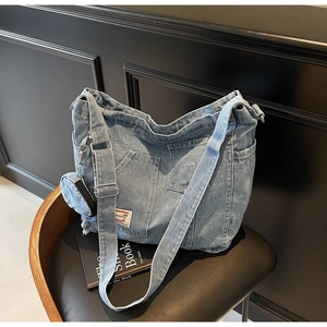 Dettaglio della borsa tote in denim blu con tasca cargo e mini portamonete