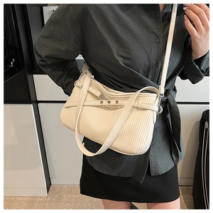 Close-up of cream pleated tote bag with vertical stripes and silver metal hardware details