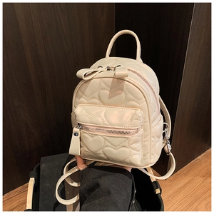 Detail of cream mini backpack featuring heart quilted patterns and adjustable straps