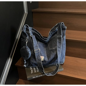 Dettaglio borsa tote in denim blu scuro con texture vintage e piccolo portamonete