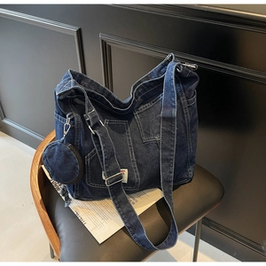 Dettaglio borsa tote in denim blu scuro con tasche e piccolo portamonete rotondo