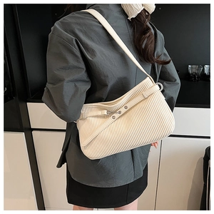 Vue latérale du sac baguette blanc texturé porté épaule avec détails de bandoulière réglable