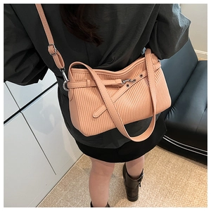 Detail view of pink pleated bucket bag featuring decorative leather strap and metal buckle