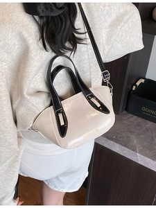 Minimalist beige and black contrast bucket bag with glossy finish and thin strap