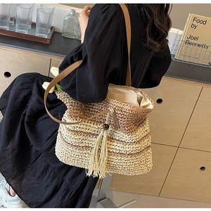 Detail of striped woven tote bag featuring long tassels and slim leather shoulder straps