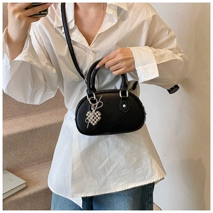 Gros plan du sac oreiller noir en cuir grainé avec pendentif coeur sur une chemise