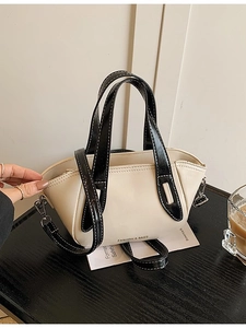 Chic cream leather bucket bag with black handles and contrast stitching for women