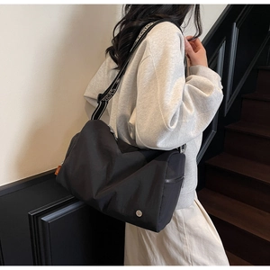 Detail view of large black sport crossbody bag with white SPORT lettered strap