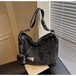 Dettaglio della borsa tote in denim grigio scuro con tracolla e mini portamonete
