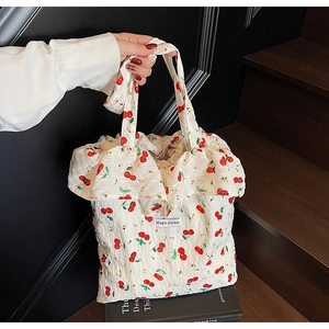 Detail of cherry print handbag with ruffle edges and Magic Pocket woven label
