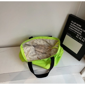 Interior detail of neon green tote bag showing brand printed lining and zipper pocket