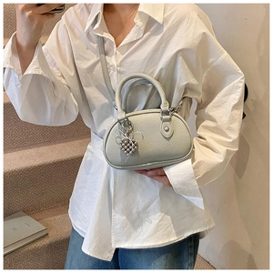 Détail du sac polochon en cuir grainé vert clair avec des ferrures argentées chic