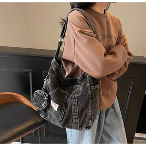 Dettaglio della borsa tote in denim grigio vintage con portamonete abbinato e tasca frontale