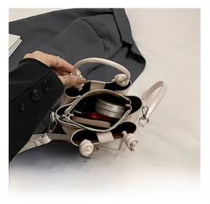 Internal view of cream bucket bag showing multi-compartment storage for cosmetics