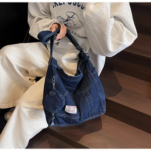 Dettaglio della borsa tote in denim blu scuro con portamonete e stile cargo retrò