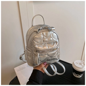 Close-up of mini silver metallic backpack featuring heart quilting and bow detail