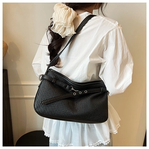 Detail of black pleated bucket bag with vertical texture and silver metal eyelets