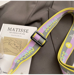 Detail of colorful woven shoulder strap with jacquard lettering and adjustable buckle