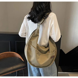 Detail view of khaki nylon hobo bag showing the Z-yousi leather logo and adjustable strap