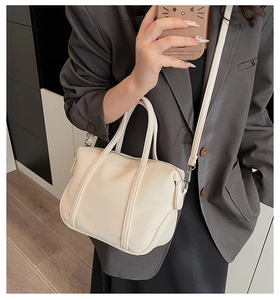 Detail of off-white lychee texture handbag with silver hardware and shoulder strap
