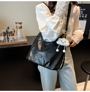 Détail du sac à bandoulière vintage plissé noir avec breloque nuage en peluche
